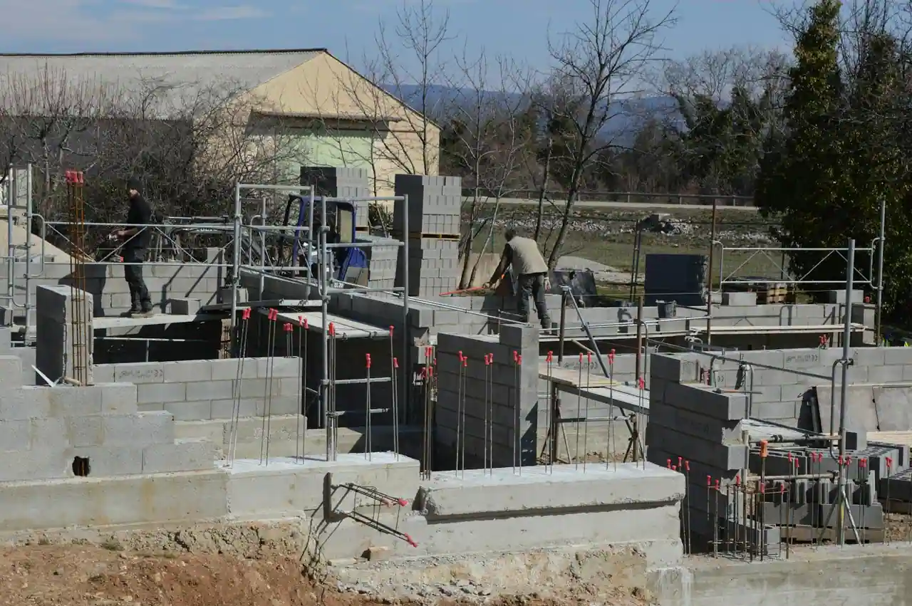Maison individuelle neuve en construction avec échafaudages et ouvriers sur le chantier