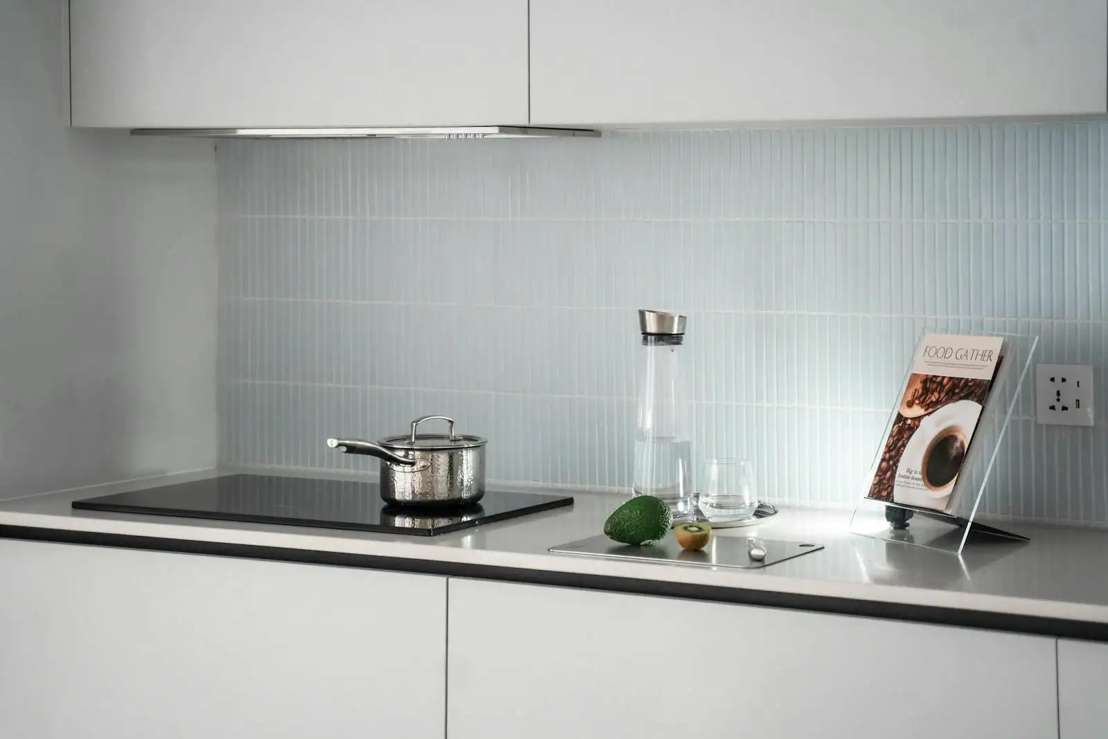 Cuisine contemporaine avec crédence en verre laqué blanc, plan de travail en bois clair et plaque à induction