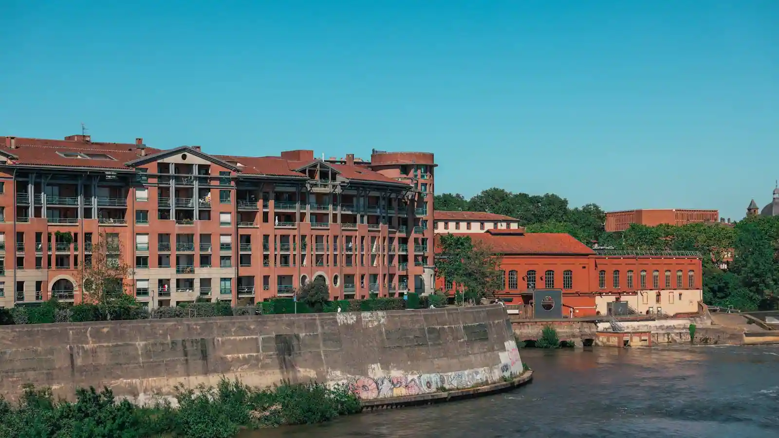 Vue panoramique du centre de Toulouse avec immeubles en brique rose et toits en tuile, ambiance fin de journée