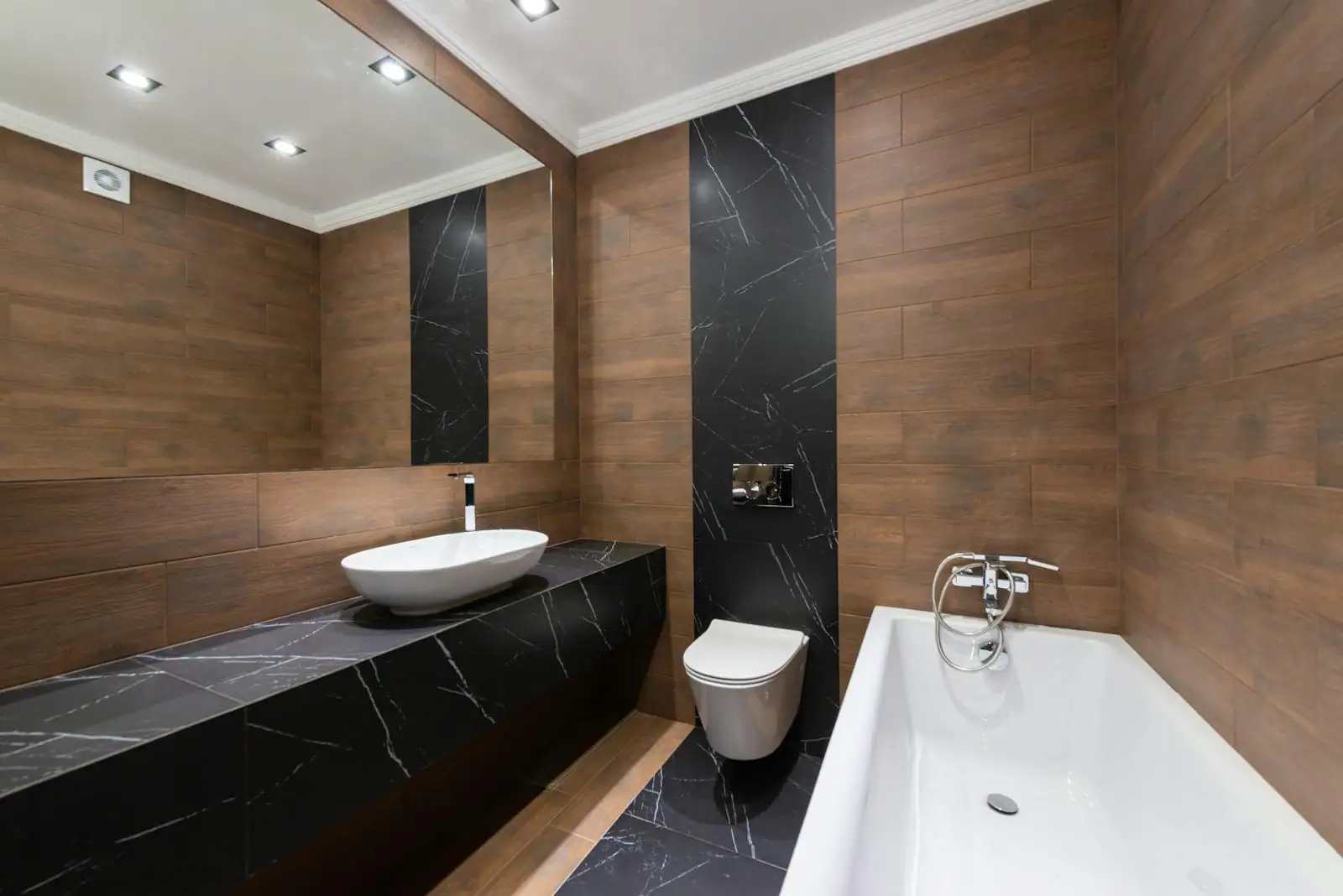Toilettes modernes décorées avec carrelage métro et accessoires noirs, éclairage indirect