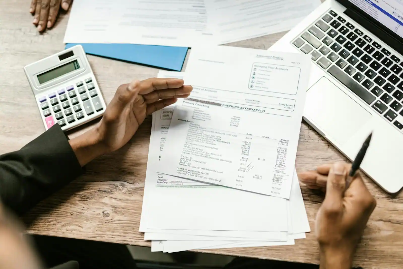 Bureau avec calculatrice, documents fiscaux, plan d'appartement et clés posées sur un dossier d'investissement immobilier