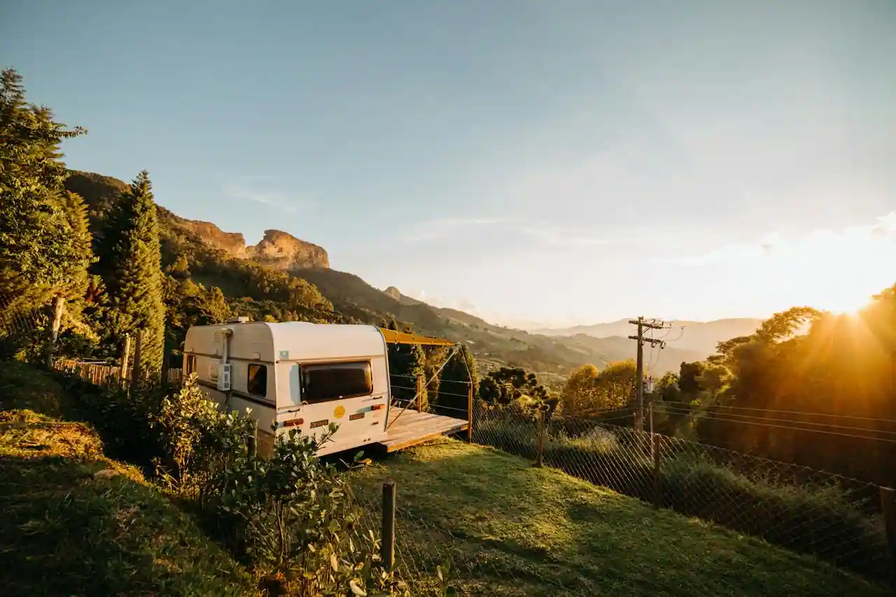Camping-car stationné dans un paysage de campagne française au coucher du soleil
