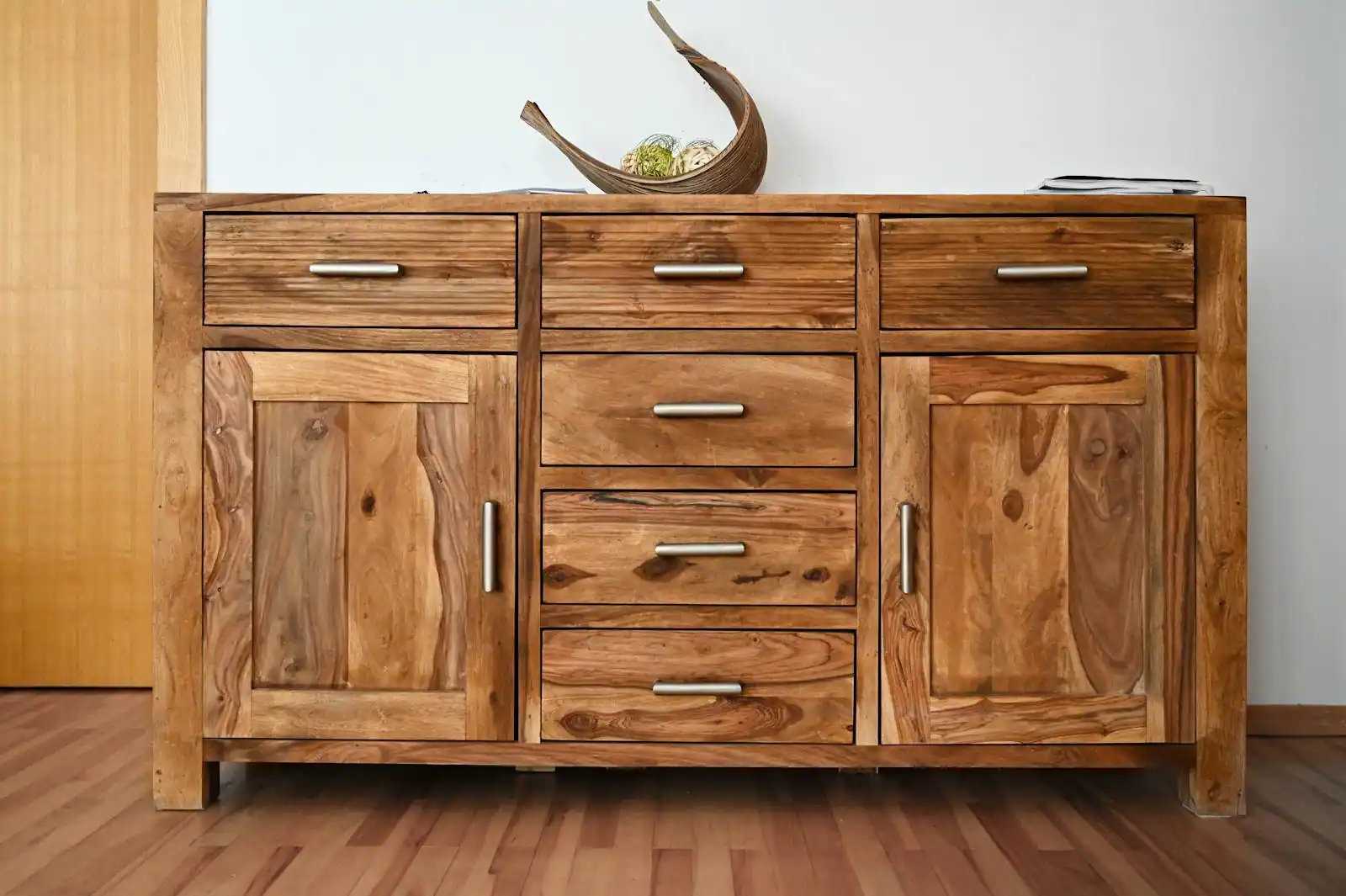 Bureau d'un home office avec caisson à roulettes et bibliothèque ouverte en bois clair