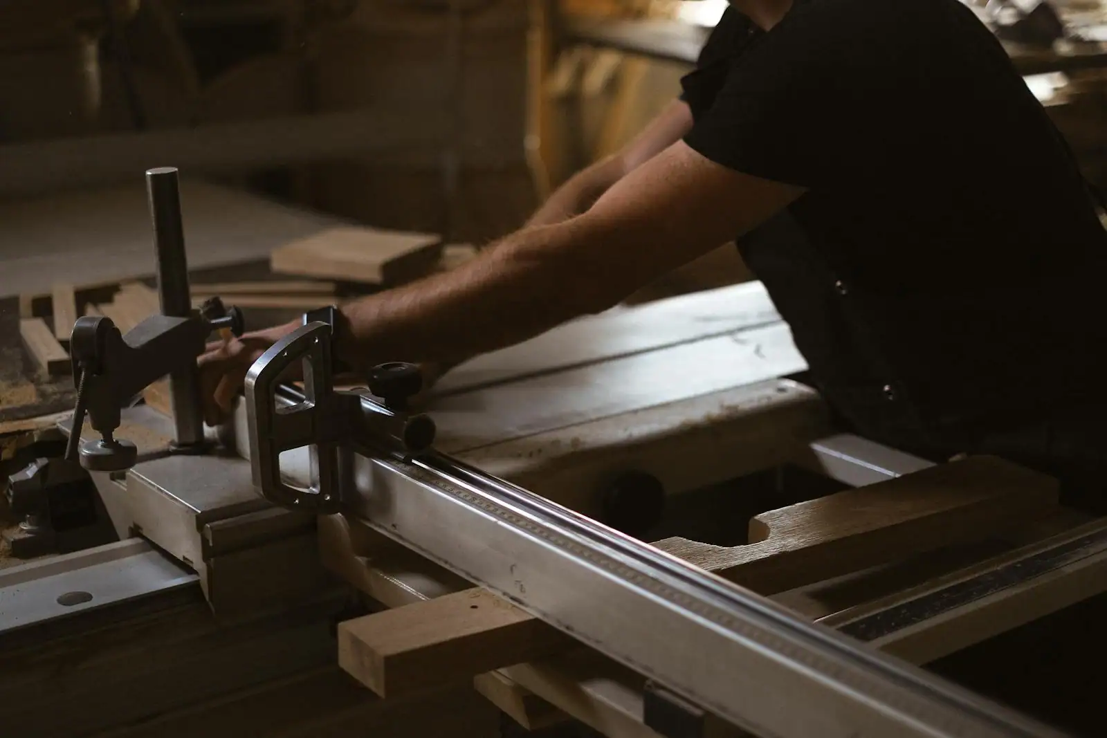 Atelier d'ébénisterie française avec un artisan travaillant une table en chêne massif