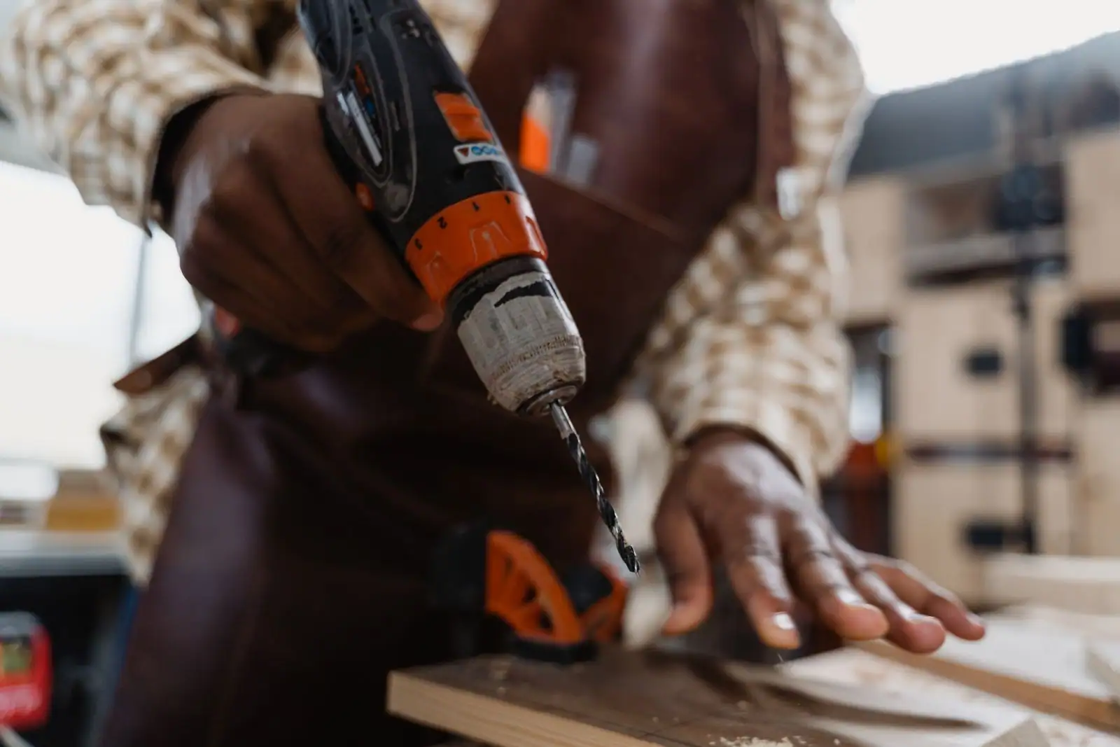 Perforateur Hilti rouge posé sur un chantier béton, avec poussière de perçage et mèches SDS au premier plan