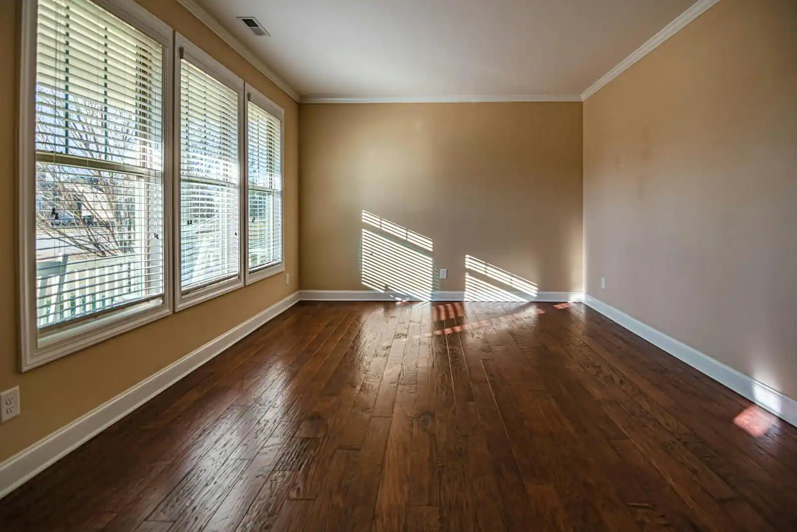 Parquet ancien en chêne massif en cours de rénovation avec ponceuse dans un appartement lumineux