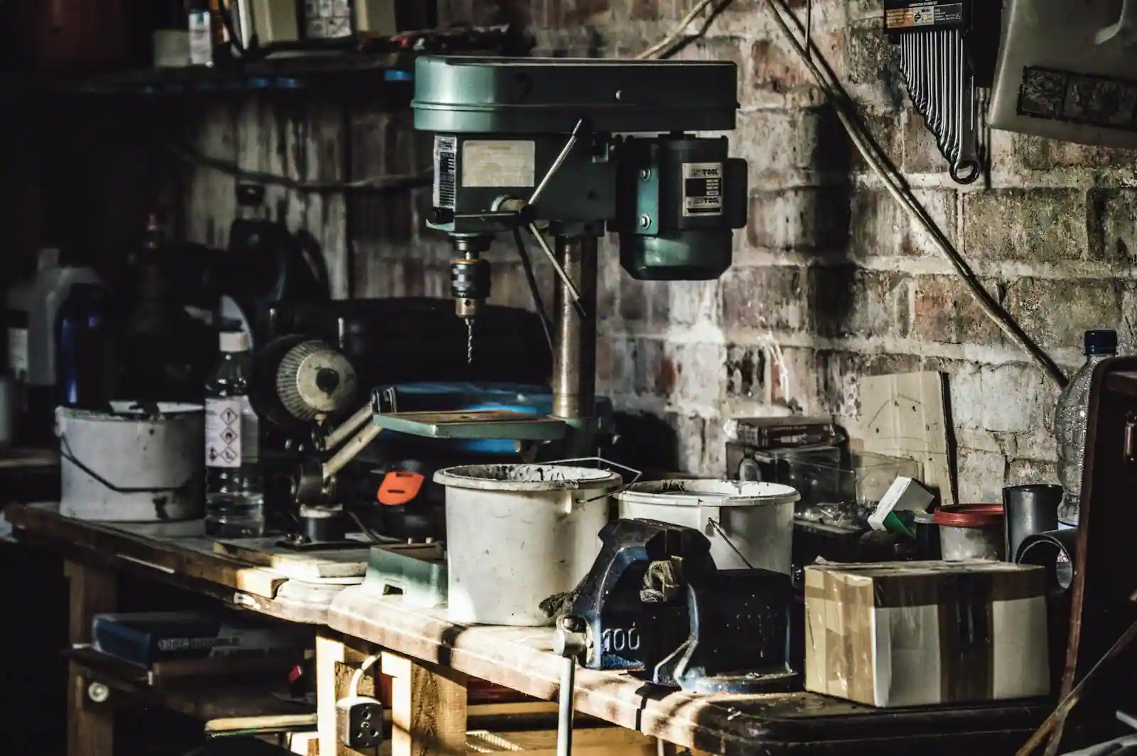Établi d'atelier avec outils de bricolage rangés, perceuse et clés posées sur un plan de travail