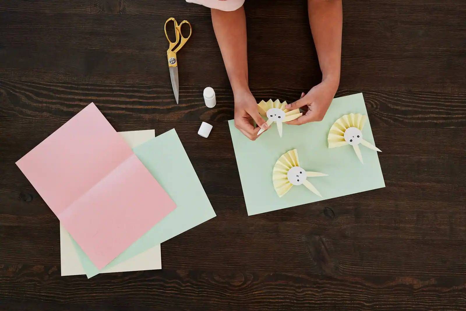 Mains d'enfant décorant un bricolage de Pâques en papier coloré