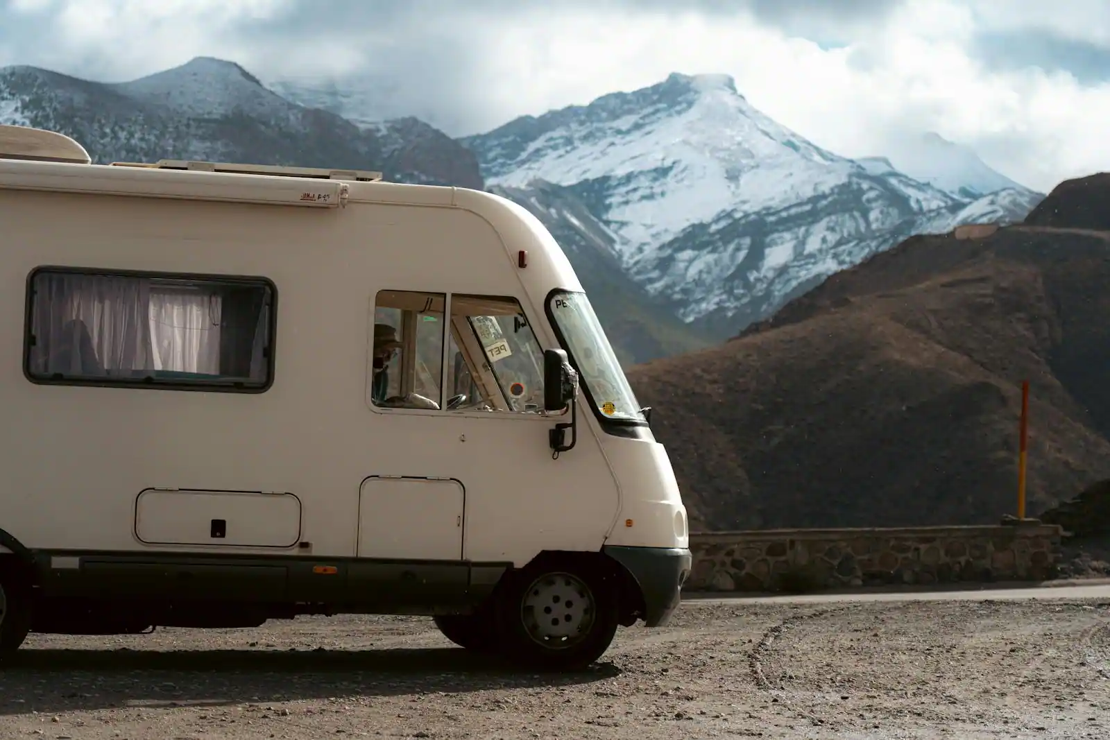 Van aménagé garé face à un paysage de montagne au lever du jour