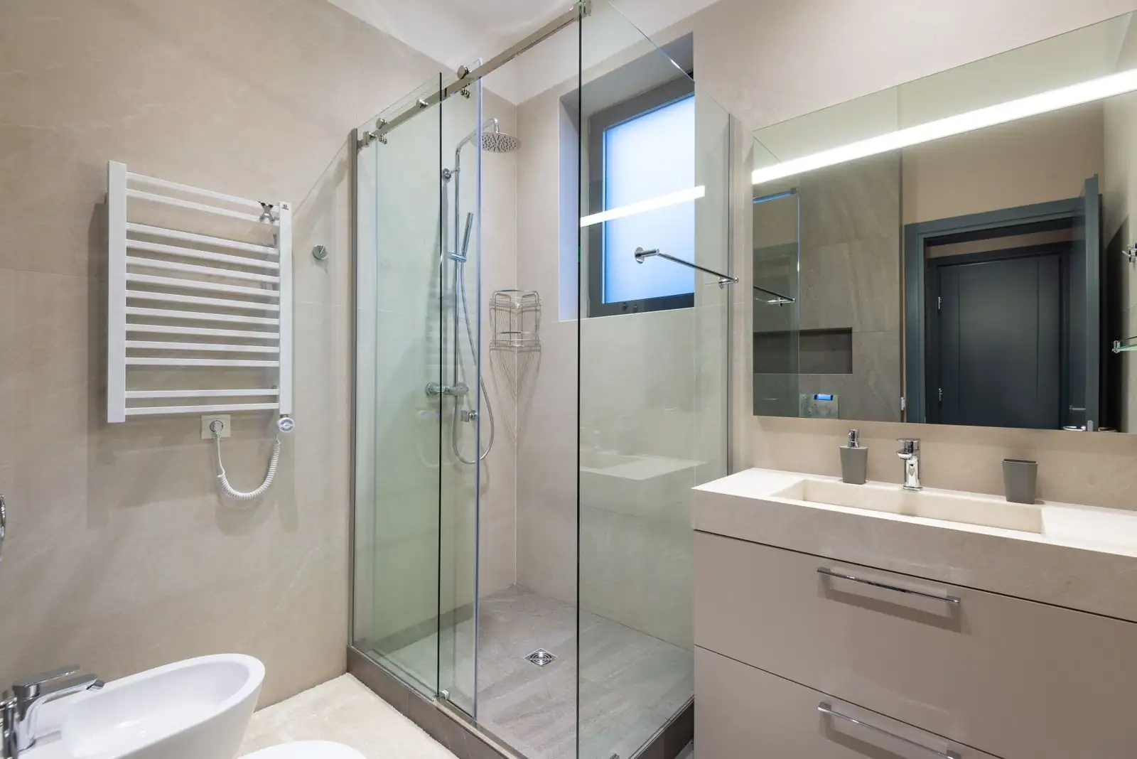 Salle de bain moderne aux lignes épurées avec douche vitrée et meuble suspendu à double vasque