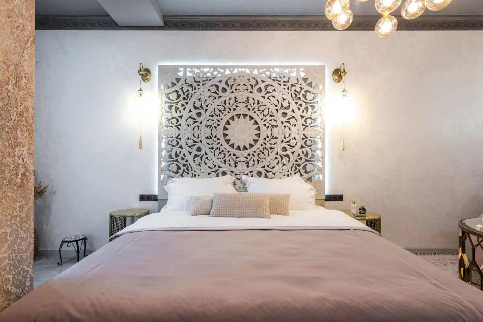 Chambre de style marocain : panneau ajouré rétroéclairé en tête de lit, appliques et chevets en laiton