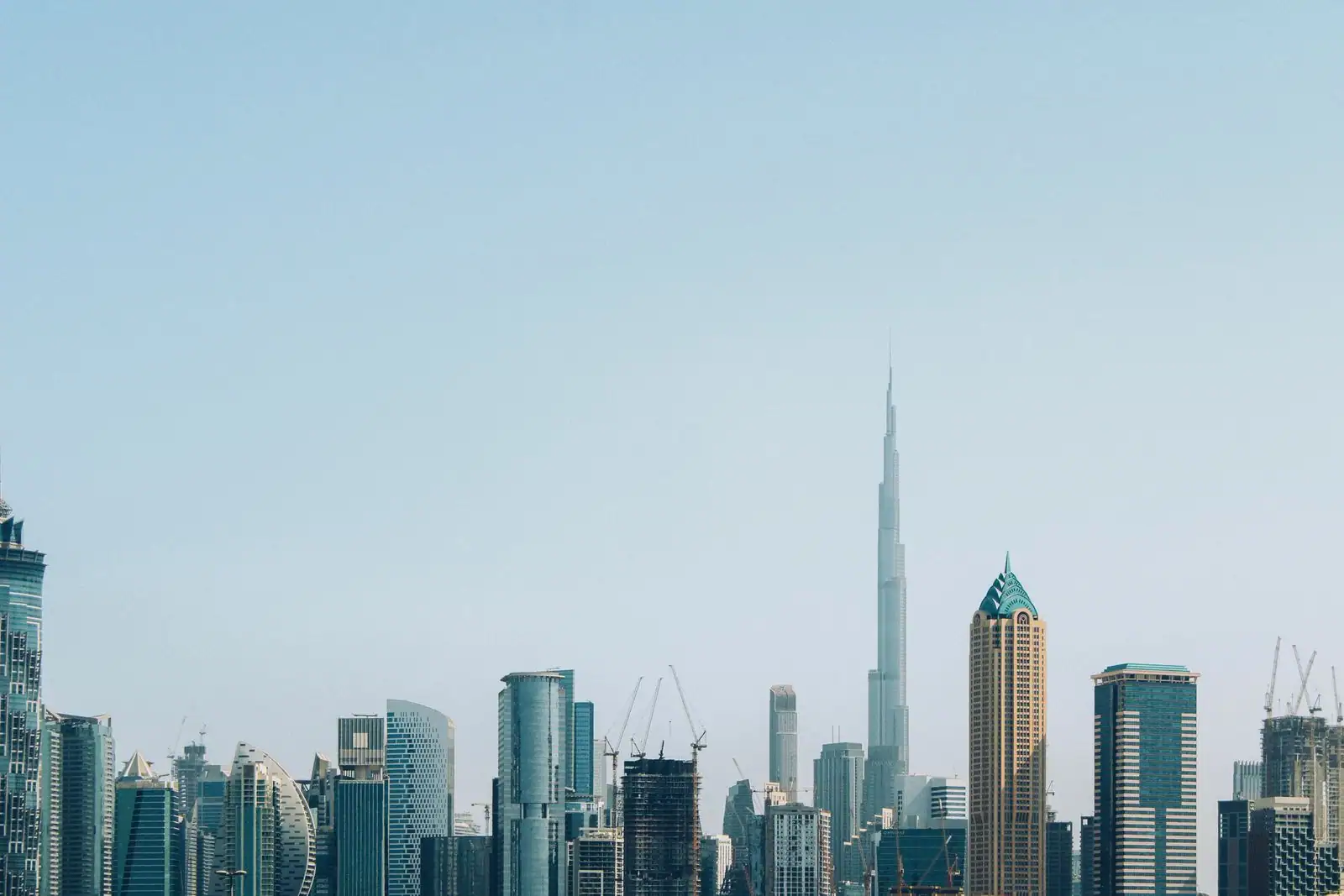 La Burj Khalifa, silhouette effilée dominant la skyline de Dubaï hérissée de tours et de grues.