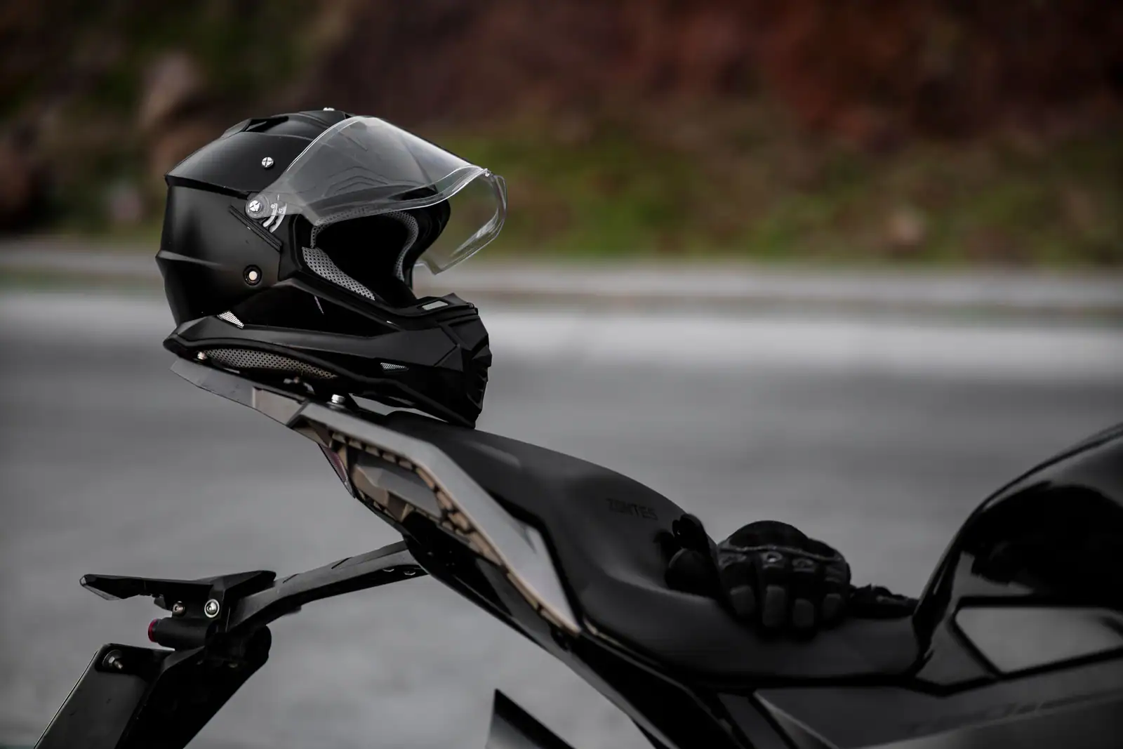 Casque intégral et gants posés sur la selle d'une moto routière, prêts pour le départ